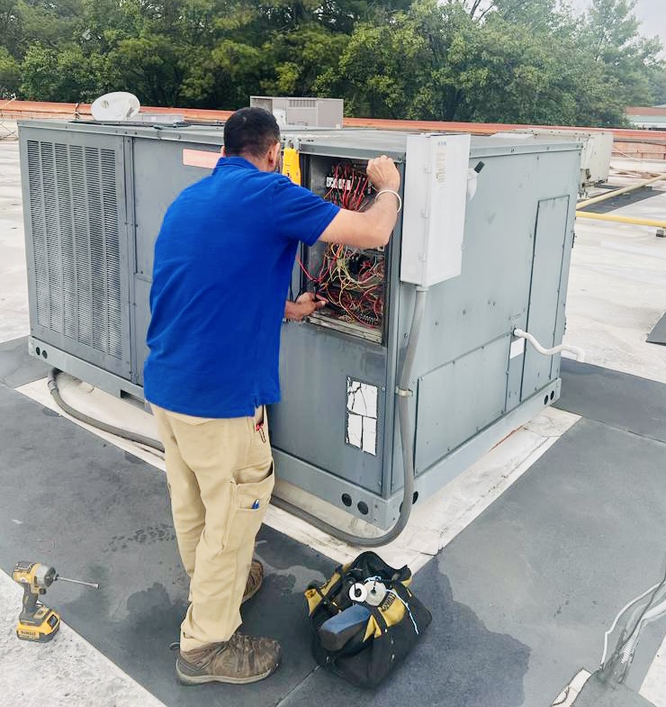 Delta Services 247 technician repairing a packaged rooftop HVAC system