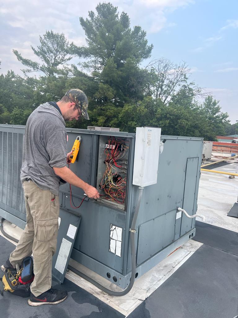 Delta Services 247 technician running electrical diagnostics on a rooftop HVAC unit in Northern Virginia